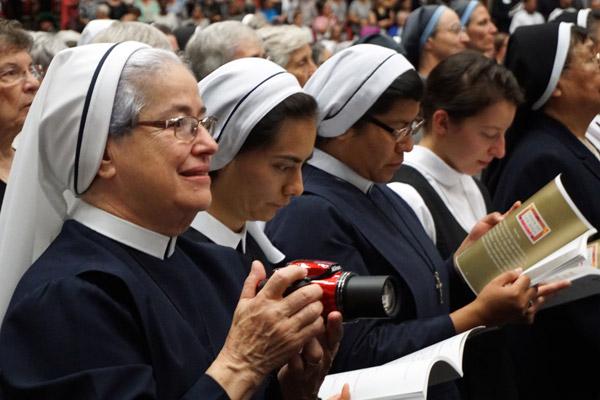 Sister Norma Munoz, diocesan director of Hispanic ministry, takes photos during the beatification Mass to share with her religious community. (Malea Hargett photo)