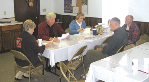 Msgr. Richard Oswald reviews bids for parish work with parish council members Zina Rosso (left), Mary Radley, Deacon Tony Picciano and Chuck Ballegeer.