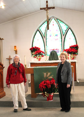 Patty Butler (left) and Kate Schuncke consider St. Matthew Church home. The stained glass window behind the altar is from the 1879 church and dedicated to S.S. Semmes, one of the early Catholic settlers in Osceola.