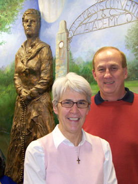 Sister Deborah Troillet, RSM, and Denny Ferra in front of a statue of St. Catherine McAuley in a newly renovated section of Mount St. Mary Academy.