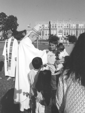 A Hispanic woman shows reverence to Bishop McDonald by kissing his ring before he presides at the late afternoon Mass at Encuentro Hispano at St. John Center in Little Rock in 1997. More than 1,500 Hispanics attended.