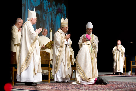 Bishop Anthony B. Taylor kneels during his ordination Mass at the Statehouse Convention Center in Little Rock June 5, 2008, in front of Archbishop Eusebius Beltran of Oklahoma City.