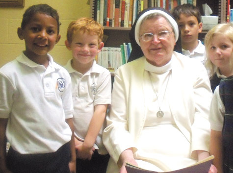 Sister Christopher Flowers, OSB, spends time with Zachary Koeller (from left), Robin Daughhetee, William Talley and Kennedy McHugh in the library at St. Michael School in West Memphis.
