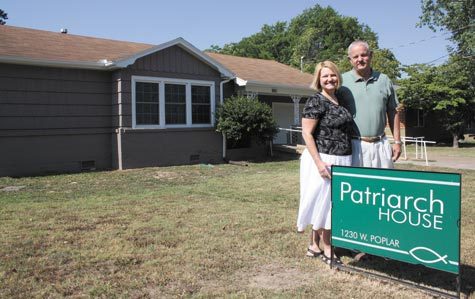 Patti and Rick Brunner, parishioners at St. Vincent de Paul Church in Rogers, stand in front of Patriarch House. They bought, remodeled and dedicated the ministry house adjacent to the church in the fall of 2011.