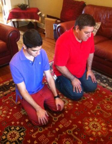 Mustafa "Mo-Mo" Filat (left) and his father, Isaac, pray toward Mecca -- the birthplace of Muhammad -- in their Little Rock home. Mo-Mo Filat is a member of the Islamic Center of Little Rock with his family.