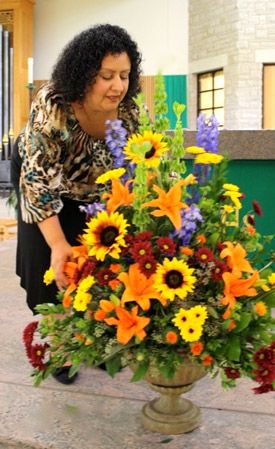 Rosario Castrejon, wife of soon-to-be-ordained deacon Arturo Castrejon, cares for altar flowers at St. Vincent de Paul Church in Rogers.