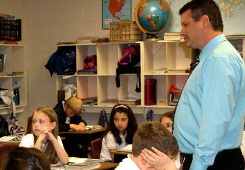 Mike Martin, a fourth-grade teacher at St. Vincent de Paul School in Rogers and a Baptist minister for Northeast Southern Baptist Church in Fayetteville, listens to his students as they discuss a lesson in social studies.