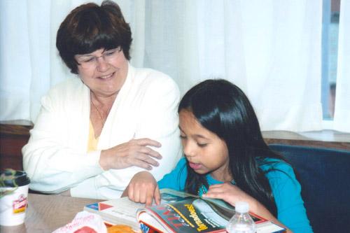 Local attorney Lucy Buergler tutors a young student in reading for the Sisters of Mercy Reading Program at Immaculate Conception Church in Fort Smith.