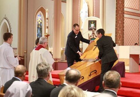 North Little Rock Funeral Home employees close the coffin of Bishop Emeritus Andrew J. McDonald during his funeral Mass April 8 at the Cathedral of St. Andrew in Little Rock.