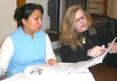 Dominga Bila, a member of St. Edward Church, listens as tutor Beth Collier goes over phrases about illnesses in the English as a Second Language (ESL) program. About 20 certified tutors rotate teaching the classes.