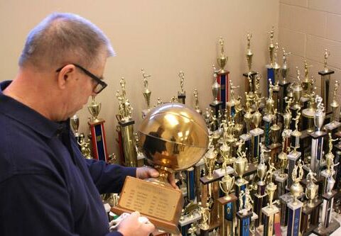 Frank Zakrzewski, maintenance engineer at Our Lady of Good Counsel Church in Little Rock, polishes a trophy listing Good Counsel as Arkansas State Parochial Champions in basketball. The parish is giving away trophies to former students until April 1.