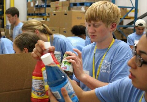 Jonathan Semmler of Sacred Heart of Jesus Church in Hot Springs Village joins other Catholic Charities Summer Institute participants in sorting and packing canned food items at the Arkansas Foodbank in Little Rock in July 2013.