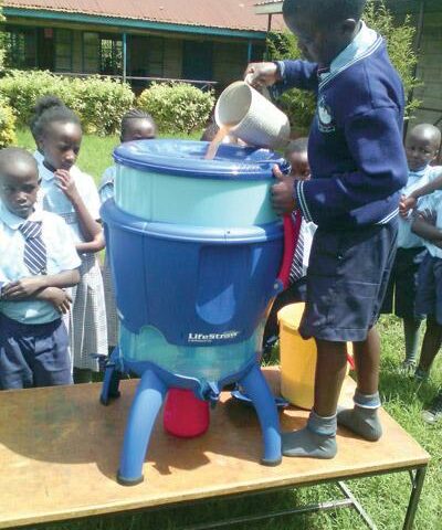 A student at Magutuini School outside Nairobi, Kenya, pours collected water into the LifeStraw Community filter purchased for the school by donations through Replenish, a ministry-based nonprofit.