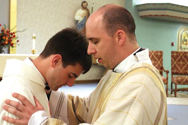 At the conclusion of his Mass of Ordination at St. Joseph Church in Conway June 2, Deacon William Burmester (right) blesses Deacon Mike Johns, who became a transitional deacon May 24 in Jonesboro.