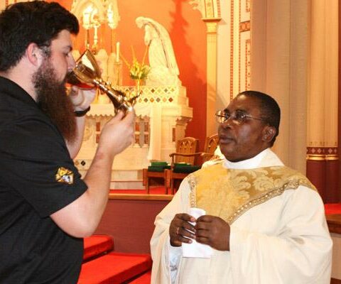 Seminarian Brian Cundall takes Communion from Father Chris Okeke, associate pastor at St. Peter the Fisherman Church in Mountain Home, during the Jubilee Mass at the Cathedral of St. Andrew in Little Rock June 27.