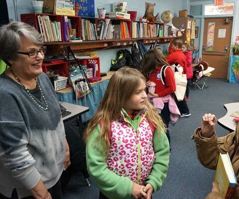 Junior Vega, third-grade teacher at St. John School in Russellville, listens to student Makili Hardman, 9, (right) and Savannah Key, 8, at the end of the school day Jan. 8. Vega has been a teacher for about 50 years.