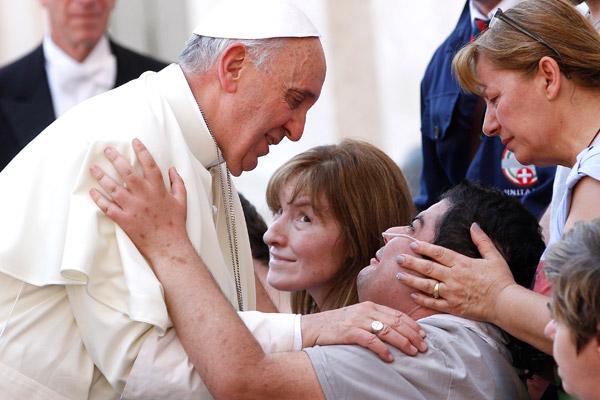 Pope Francis greets a disabled man after celebrating Mass in St. Peter&#039;s Square at the Vatican in this June 17, 2013, file photo. The pope has shown special concern for the aged, the sick and those with disabilities. (CNS / Paul Haring)