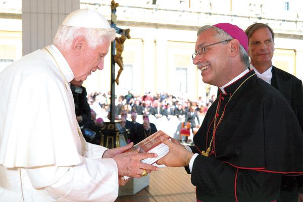 While in Rome for the diaconate ordination of then-seminarian Andrew Hart, Bishop Anthony B. Taylor attends the general papal audience Oct. 5, 2011, and gives Pope Benedict XVI a hardback copy of the new Little Rock Study Bible, which was first published that summer by Little Rock Scripture Study. (Courtesy L&rsquo;Osservatore Romano)