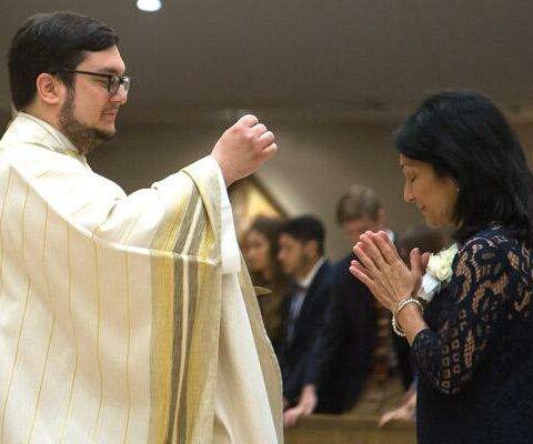 Father Stephen Elser gives Communion to his mother Angie during his ordination Mass June 2 at Christ the King Church in Little Rock. He was one of eight men ordained for the diocese in May and June.