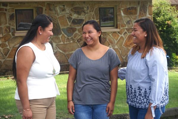 Sisters Yemina Arzola (left), 27, Veronica Arzola, 21 and Claudia Arzola, 27, share laughs outside of their parish, St. Anne Church in North Little Rock.