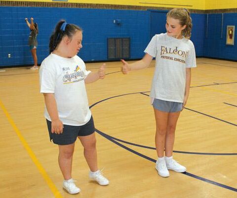 Cassidy Wharton (left) gives the thumbs up to her fellow cheer squad member, Immaculate Conception School seventh-grader Hope Harvey. Wharton, an eighth-grader, is active in several sports and activities and well-known around school.