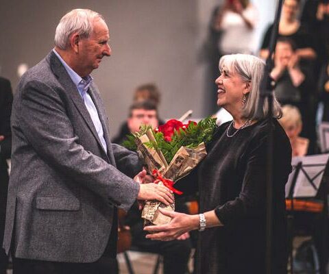 Ken Baker presents flowers to his wife Robbie Baker Nov. 20 after a concert in Fayetteville that she composed for her 70th birthday.
