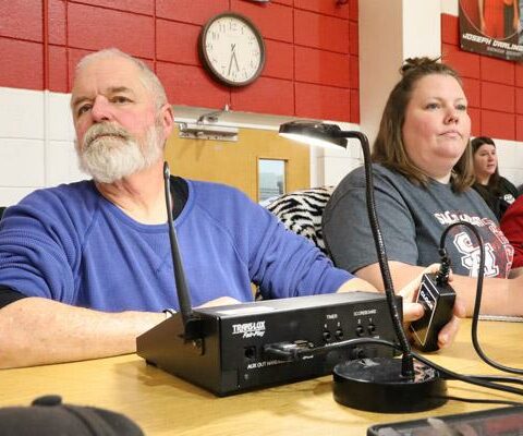 Mickey Powell works the clock during a recent Sacred Heart home basketball game assisted by bookkeeper Ashley Hoelzeman. The duo have been a keeping score for the Morrilton school for the past four years.