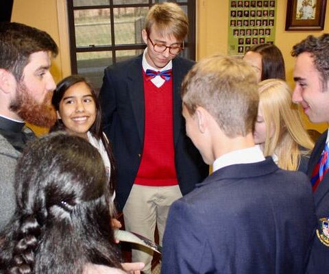 Ozark Catholic Academy students talk with St. Raphael Church associate pastor Jon Miskin after Mass at the school Oct. 18. A $3 million gift was given to assist families with tuition at Ozark Catholic Academy in Tontitown.