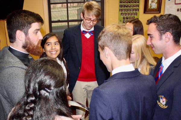 Ozark Catholic Academy students talk with St. Raphael Church associate pastor Jon Miskin after Mass at the school Oct. 18. A $3 million gift was given to assist families with tuition at Ozark Catholic Academy in Tontitown.
