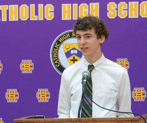 Sam Ray speaks after signing on as a seminarian for the Diocese of Little Rock, April 28 in the nearly empty gym at Catholic High School in Little Rock. He was joined by his parents and Bishop Anthony B. Taylor.