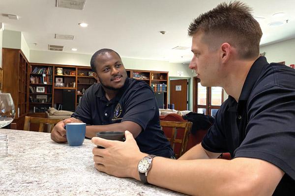 Seminarians Duwan Booker (left) and Joel Brackett chat at the House of Formation in Little Rock, where the two have been roommates. The friends met in college while teammates on the Hendrix Warriors football team in Conway. They experienced a conversion in college, studying Catholicism and growing in faith. They are both in formation to become priests for the Diocese of Little Rock in 2025.