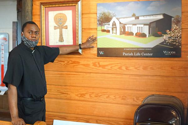Father Leon Ngandu, SVD, pastor of St. Bartholomew Church, shows the architect&rsquo;s rendering July 31 of the Parish Life Center that will be built next to the church and rectory in Little Rock. (Malea Hargett photo)