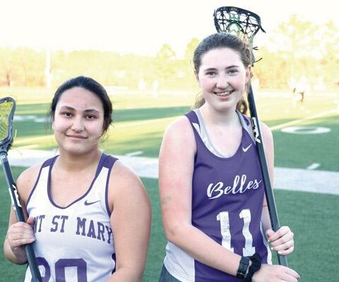 Senior lacrosse athletes Sene Harness (left) and Elise Smith, share a moment before practice. The two friends and teammates at Mount St. Mary Academy have played on the team since sophomore year.