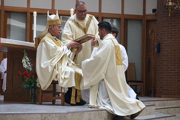 As part of the diaconate ordination rite, Bishop Anthony B. Taylor hands the newly ordained Deacon Jaime Nieto the book of the Gospels, saying, &ldquo;Receive the Gospel of Christ, whose herald you have become. Believe what you read, teach what you believe and practice what you teach.&rdquo; (Aprille Hanson Spivey photo) 