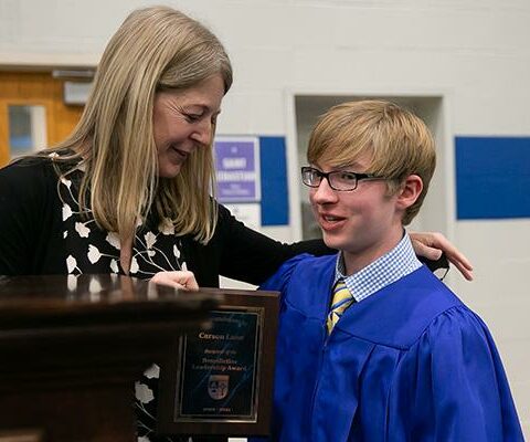 Carson Lane, a graduating ninth grader (right), receives the Benedictine
Leadership Award from principal Dr. Karen Hollenbeck at a Trinity
Junior High graduation ceremony May 17 in Fort Smith.