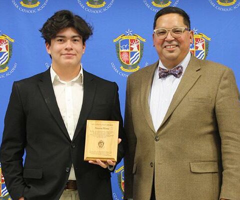 Stephen Flores accepts the Docilitas Award from head of school John Rocha at the Ozark Catholic Academy awards banquet May 6.