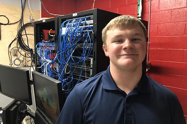 Thomas Buser, 18, smiles in the server room at Sacred Heart High School
in Morrilton May 10. Since sixth grade, he has helped the school with IT
support and setting up networks.
