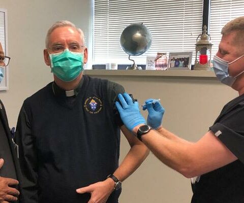 Bishop Anthony B. Taylor receives his COVID-19 vaccination Jan. 11 at St. Vincent Infirmary in Little Rock with hospital chaplain Father Warren Harvey by his side. The bishop received the Pfizer-BioNTech vaccine.