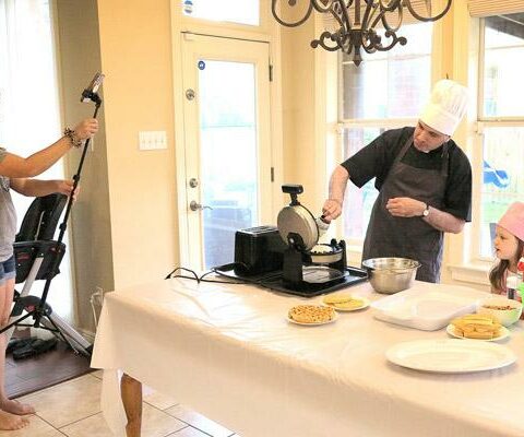 Becky Delatte, a parishioner of Divine Mercy Church in Kenner, La., films a Facebook Live segment in which her pastor, Father Robert Cooper, and her 4-year-old daughter, Lucy, make "Monstrance Waffles." The video, which aired June 3, 2021, taught viewers about the sacred receptacle before the feast of Corpus Christi. It also led to "Cooking with Father Cooper," a Facebook Live series that is produced and filmed by Delatte in her Kenner kitchen.