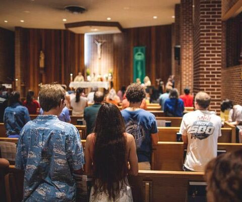 University of Arkansas students pray during Mass Aug. 15 at St. Thomas Aquinas University Parish on the campus of the University of Arkansas. Pastors and campus ministers are eager for young adult Catholics to attend Mass, Bible studies and other Catholic Campus Ministry activities to keep them connected to their faith.