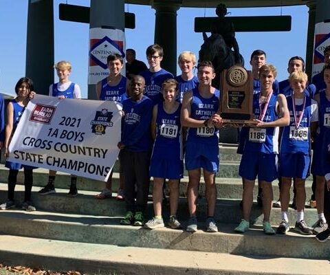 Members of Ozark Catholic Academy's cross country team pose with the 2021 1A State Championship trophy in Hot Springs.