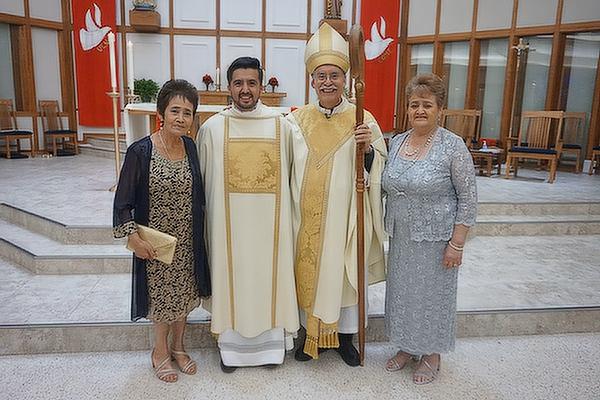 Deacon Jaime Nieto (center left) stands with Bishop Anthony B. Taylor; his aunt, Beatriz Nieto Bautista (left) and mother, Maria Del Carmen Nieto Bautista, at his diaconate ordination May, 21, 2021 at St. Raphael Church in Springdale.