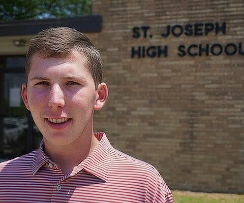 Landon Baker, 18, smiles outside St. Joseph High School in Conway May 12. The senior, who is studying aviation, converted to Catholicism with his family in 2019, thanks in part to his time at the school.