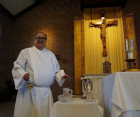 Marc Rios, deacon candidate and resident manager at St. John Manor, prepares the altar for daily Mass at Morris Hall in the St. John Center, May 18.