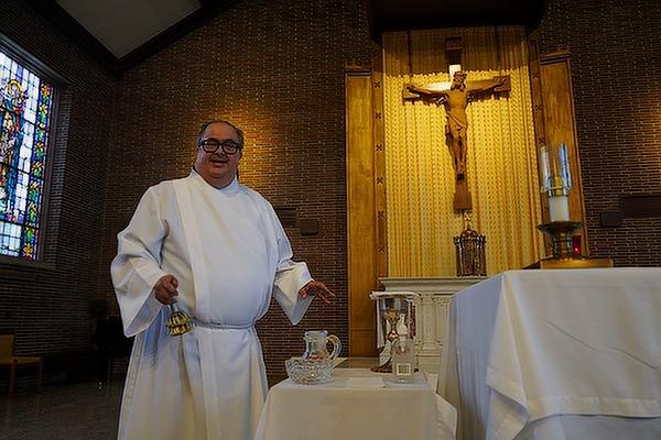 Marc Rios, deacon candidate and resident manager at St. John Manor, prepares the altar for daily Mass at Morris Hall in the St. John Center, May 18.