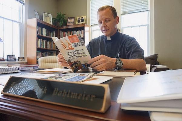 Bishop-elect Erik Pohlmeier reads materials in his Little Rock office in September 2018 related to programs he brought to the diocese that year as then director of faith formation for the diocese: Called and Gifted Workshops for individual parishioners and Ananais Training for ministry leaders and volunteers.