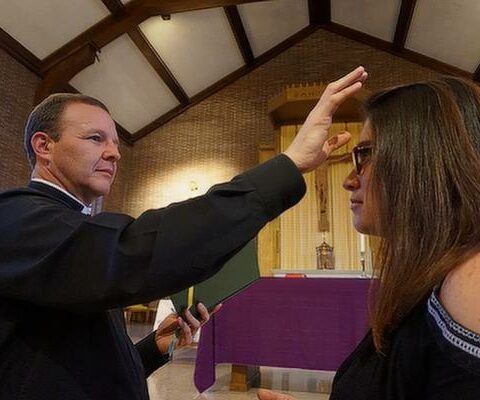 Bishop-elect Erik Pohlmeier, in his role as diocesan director of faith formation as well as theological consultant to Arkansas Catholic, demonstrates the blessing that takes place during the anointing of the sick with Jasmine Hogan to illustrate a newspaper feature on the healing sacrament in February 2018.