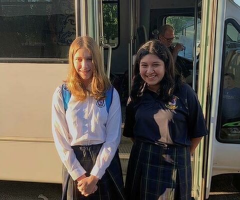 Elizabeth Cauthron (left), a graduate of St. Joseph School in Paris, and Genesis Rosales, a graduate of Trinity Catholic School in Fort Smith, ride the bus to Ozark Catholic Academy for the first day of school Aug. 15.