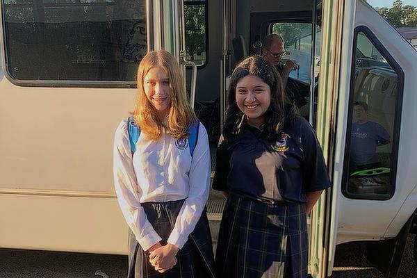 Elizabeth Cauthron (left), a graduate of St. Joseph School in Paris, and Genesis Rosales, a graduate of Trinity Catholic School in Fort Smith, ride the bus to Ozark Catholic Academy for the first day of school Aug. 15.