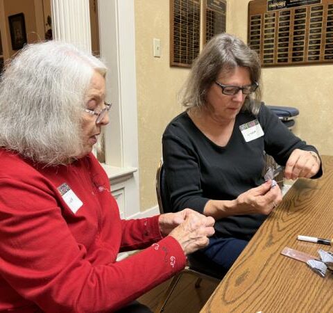Linda Howard, a member of St. Joseph Church in Conway, shows fellow
parishioner Linda Strack, a volunteer with Beacon of Hope Ministry, how to
make a memorial ornament Nov. 9.